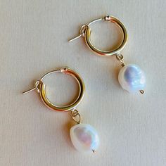 Lanai Pearl and Small Hoop Earrings. Inspired by the simple beauty of pearls, this earring showcases an asymmetrical pearl paired with a shinny golden hoop, creating a classic and feminine earring perfect for day- and night- wear.    14Kt Gold Filled hoop   White Potato Peal Pearl  Approx. 1.5" long  Made in USA Hoop Pearl Earrings With Pearl Pendant, Pearl Pendant Hoop Earrings, Hoop Earrings With Pearl Pendant, Classic Pearl Pendant Hoop Earrings, Classic Pearl Charm Hoop Earrings, Classic Hoop Earrings With Pearl Pendant, Small Hoop Pearl Earrings, Modern Small Hoop Pearl Drop Earrings, Classic Small Hoop Pearl Earrings With Charm