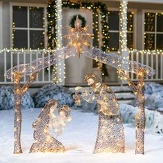 a lighted nativity scene in front of a house