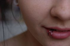 a woman with piercings on her lip and nose