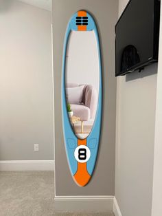 a blue and orange surfboard mounted to the side of a wall