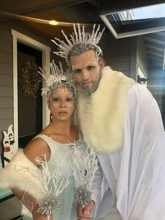 a man and woman dressed up as ice queen and snow prince standing next to each other