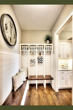 a room with some shelves and a clock on the wall next to a bench in front of it