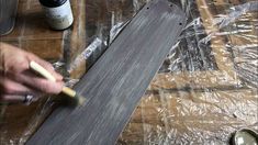 a person is painting the bottom of a skateboard with white paint and a brush