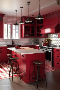 a red kitchen with checkered flooring and stools in front of the island