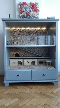 a blue bookcase with drawers and lights on top