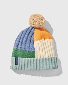 a multicolored hat with a pom - pom on the top and bottom