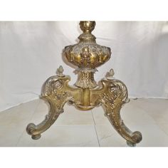 an ornately decorated table with gold paint and metal decorations on the top, in front of a white background