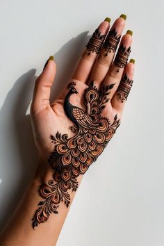 a woman's hand with henna tattoos on it