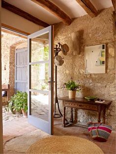 an open door leading to a room with stone walls and flooring on the side