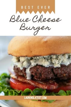 blue cheese burger with lettuce and tomato on it, sitting on a white plate