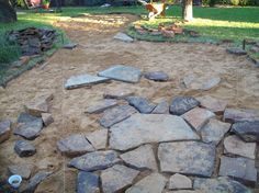 a stone path in the middle of a yard that has been built into some dirt