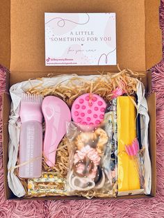 an open box with pink and yellow items in it on a pink carpeted surface