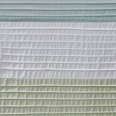 a white and green quilt with horizontal stripes