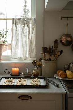 a tray with food on top of a stove next to a window