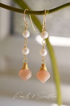 Classic elegance. These lightweight earrings are handmade with white freshwater pearls and natural peach Sunstone. Elegant Apricot Earrings For Gift, Elegant Apricot Jewelry For Wedding, Handmade Apricot Earrings In Elegant Style, Handmade Apricot Earrings Elegant Style, Elegant Handmade Blush Jewelry, Handmade Elegant Apricot Earrings, Elegant Orange Earrings With Natural Stones, Elegant Orange Pearl Drop Jewelry, Gold Briolette Pearl Gemstone Earrings