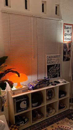 a living room filled with furniture next to a window covered in blinds and bookshelves