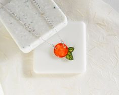 This tiny orange with little green leaves hangs on a fine silver chain. The pendant is entirely handmade from clear solid polystyrene coated in resin. The orange measures about 2 cm wide (including leaves) and the chain length adjusts between 16-18 inches. The necklace is lightweight, minimal, and comfortable. Everything in my shop is handmade by me, and I draw each tiny piece by hand, so expect the subtle differences of hand-drawing. Find matching earrings here: https://www.etsy.com/listing/501 Fruit Necklace, Necklace Orange, Kawaii Jewelry, Orange Fruit, Milwaukee Wi, Hand Drawing, Fine Silver, Matching Earrings, Chain Lengths