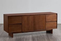 a large wooden cabinet sitting on top of a hard wood floor next to a white wall