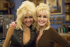 two women standing next to each other posing for a photo in front of a kitchen