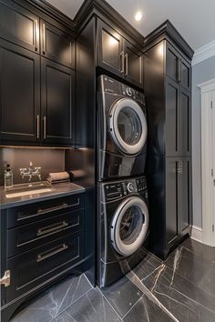 a washer and dryer in a kitchen with black cabinets