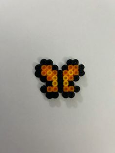 an image of some type of beaded object on a white surface with orange and yellow dots