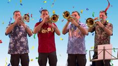 three men are playing brass instruments in front of confetti