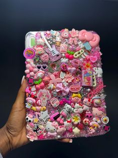 someone is holding up a case with many different things on it, including buttons and magnets