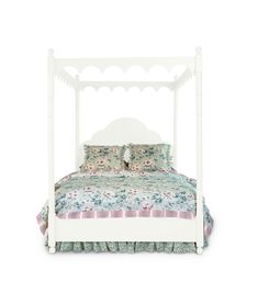 a white bed with floral bedspread and pillows