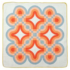 an orange and blue quilt on a white background with yellow trim around the edges that are overlapping in circles