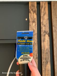 a hand is holding a plastic wood adhesive