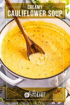 creamy cauliflower soup in a pot with a wooden spoon