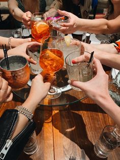 a group of people sitting around a table with drinks