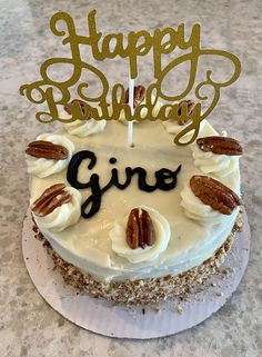 a birthday cake with white frosting and pecans on top