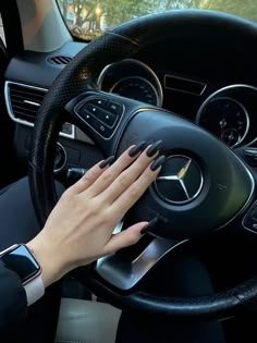 a woman's hand on the steering wheel of a car