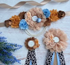 three ribbons with flowers on them sitting next to some blue and brown ribbon ties,