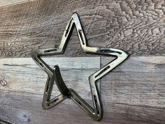 a metal star shaped object sitting on top of a wooden floor