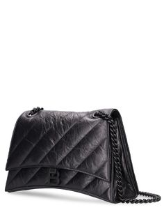 Find BALENCIAGA Medium Crush Quilted Leather Chain Bag on Editorialist. This quilted leather chain bag features a front flap with magnetic button closure, front metal logo, tonal metal hardware, a metal chain strap, three internal compartments, one internal patch pocket, one internal zip pocket, and a leather lining. It measures 19.8cm in height, 31cm in width, and 6.8cm in depth. The strap length is 19.6 inches. It can be worn on the shoulder or crossbody. Mini Chain Bag, Sling Bag Black, Balenciaga Leather, Balenciaga Women, Black Shoulder Bag, Small Shoulder Bag, Quilted Leather, Chain Shoulder Bag, Chain Bags