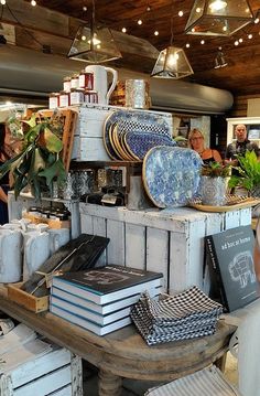 people are shopping at an antique store with blue and white dishes on the counter top