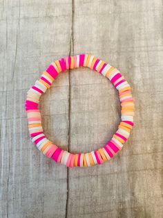 a pink and orange bracelet sitting on top of a table