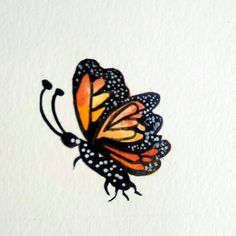 an orange and black butterfly with spots on it's wings flying in the air