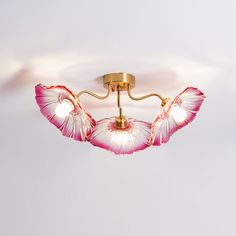 an overhead view of a ceiling light with pink flowers on the petals and two lights