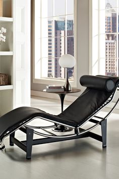 a black chaise lounge chair sitting in front of a window