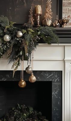 a fireplace mantel decorated with greenery and christmas ornaments, gold baubes and silver balls