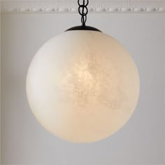 a light fixture hanging from a ceiling in a room with white walls and carpeting