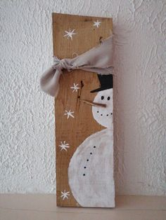 a wooden sign with a snowman painted on it