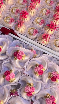 there are many decorated cookies on display in the box and one is white with pink flowers