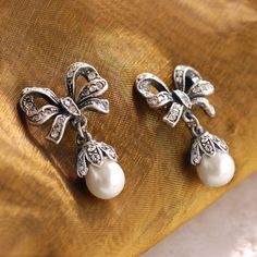 "These earrings feature our exquisite dimensional bows, set with 75 glimmering Swarovski crystals. 8mm pearls. Just the right size - demure and graceful. 1\" long by 0.75\" wide. Choice of Silver or Bronze finish. Post back. Designed and made in our Los Angeles studio. Matching piece: https://www.etsy.com/listing/215392898/bow-necklace-pearl-bow-silver-bow?ref=shop_home_active_1&ga_search_query=bow Contact us for bulk pricing and wholesale information." Jewelry Pearl Earrings, Ribbon Earrings, Locket Bracelet, Pearl Bow, Pearl Earrings Wedding, Bow Necklace, Bow Jewelry, Silver Bow, Necklace Pearl