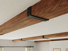 the wooden beams are hanging from the ceiling above the bed in this bedroom with white walls and wood flooring