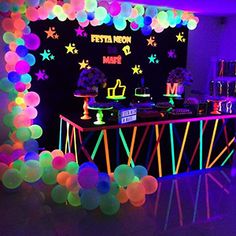 a party with neon lights and balloons on the wall, along with an ice cream bar