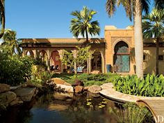 a pond surrounded by palm trees in front of a building